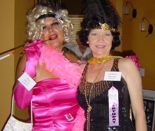 Women wearing flapper dresses in a party with a Roaring 20s theme.