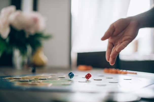 Board game and hands roll dice close-up.